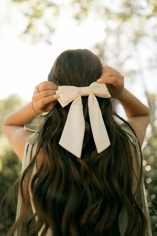 Ivory satin bow worn in long hair